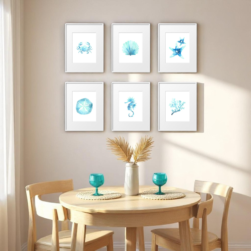 Set of six framed 8x10 beach-themed prints styled in a coastal dining nook with a round wood table, turquoise glasses, and a white vase with dried palm leaves, bathed in natural sunlight.