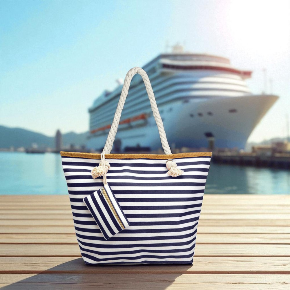 oversized navy and white striped nautical beach bag on a wooden deck with a cruise ship in the background