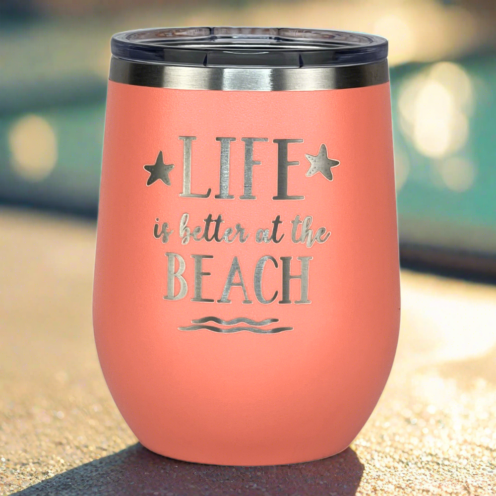 Peach insulated tumbler with lid, featuring a colorful "Life is Better at the Beach" design perfect for keeping drinks hot or cold