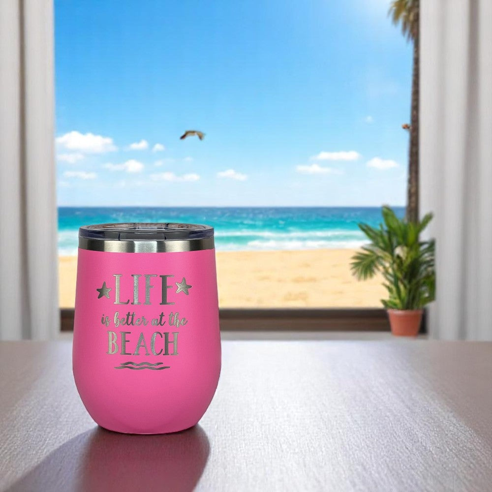 pink insulated wine tumbler on a table with ocean view