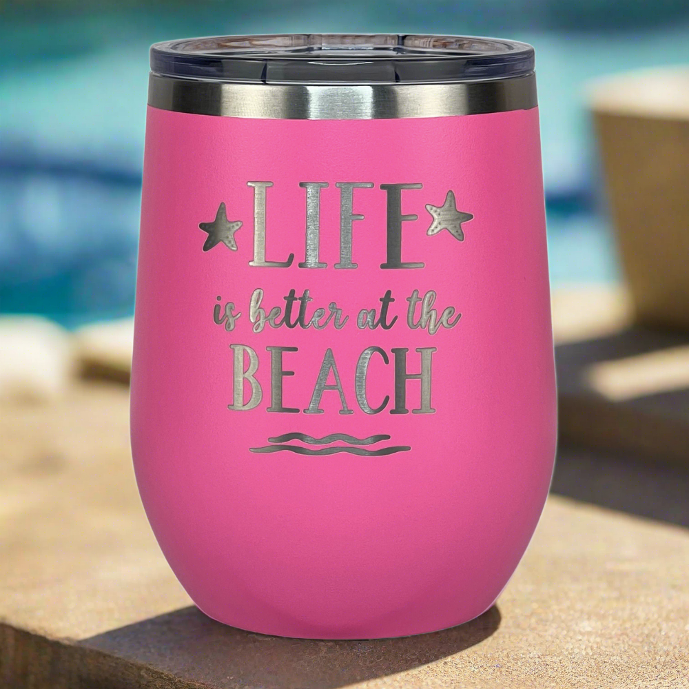 Pink tumbler with secure lid on a poolside table, ideal for beach lovers