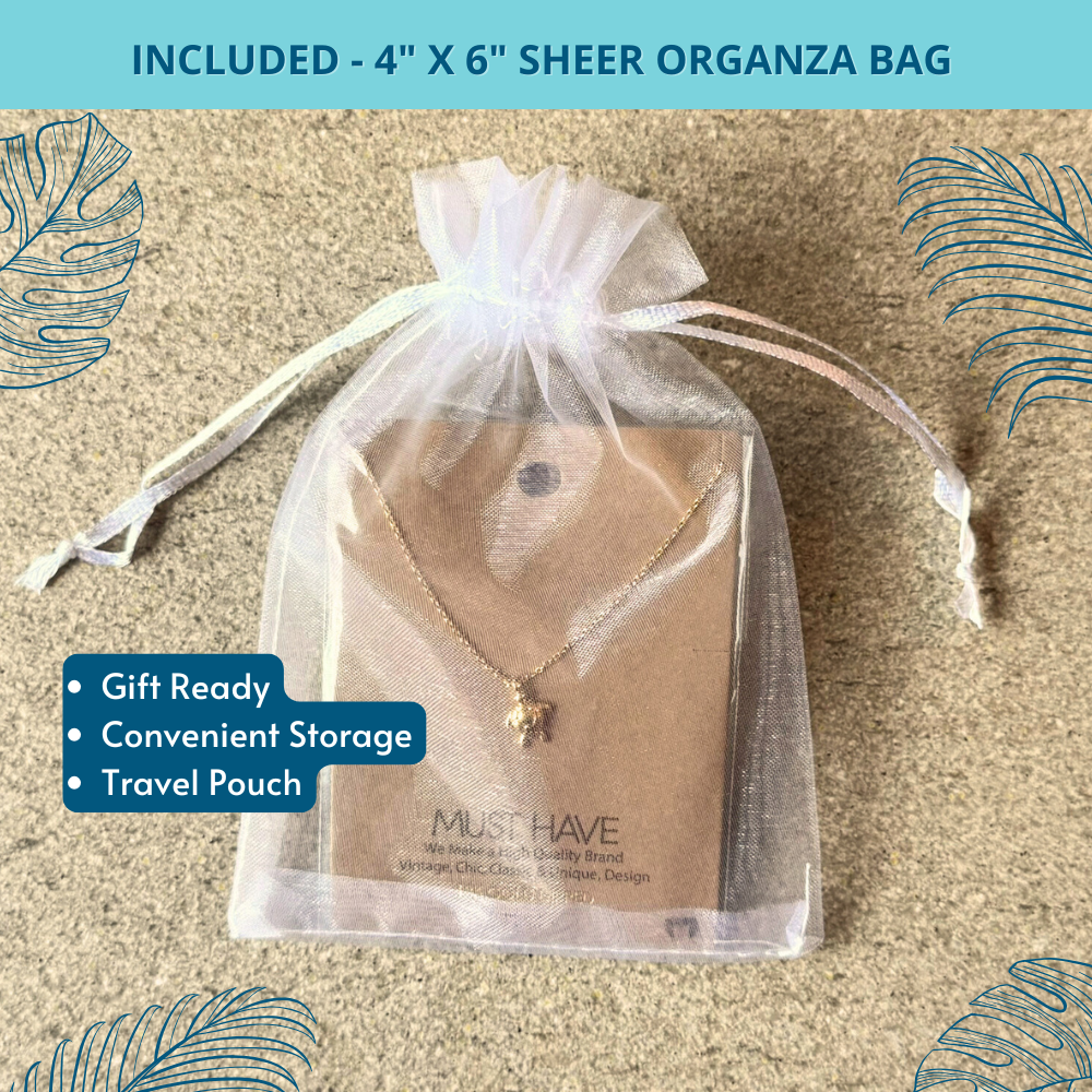 Gold sea turtle necklace in organza gift bag with ribbon, styled as a thoughtful beach lover gift for women.