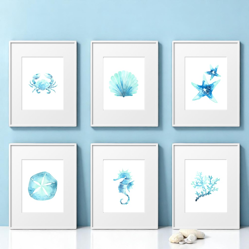 Set of 6 framed 8x10 watercolor beach art prints arranged on a soft blue background. Includes seashell, sea horse, coral, sand dollar, starfish, and crab designs.