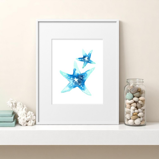 Single 8x10 starfish art print displayed in a white matted frame on a white floating shelf with coastal accents like sea glass, coral, and light blue books, styled in a bright beach-themed home.