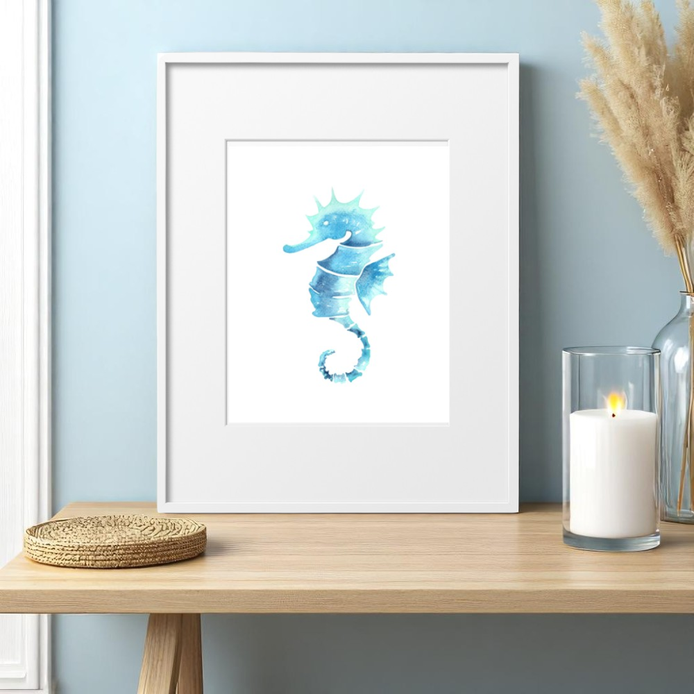 Single 8x10 framed seahorse art print displayed above a coastal nightstand, styled with a clear vase of sea oats, a white candle, and natural textures in a soft, beach-inspired bedroom setting.