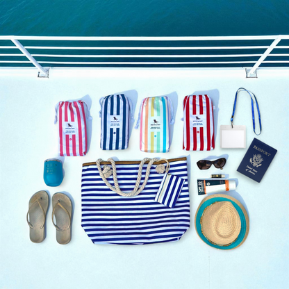 Navy and white striped beach tote bag shown in flat lay style on cruise ship deck with soft natural lighting