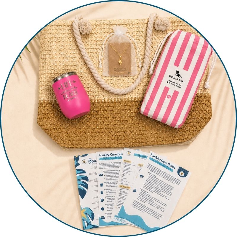 Pink beach bag gift set flat lay with straw beach bag, pink striped towel, pink tumbler, gold-dipped conch shell necklace and printed bonus cards.