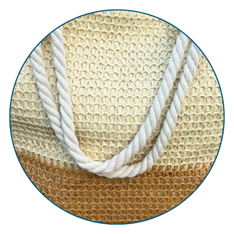 Cute straw beach bags with soft rope handles resting on a chair, ready for a beach day.