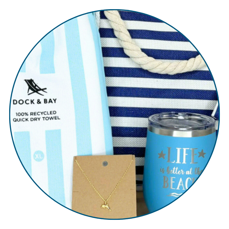close-up of blue beach lover gift set including a towel, tumbler, and necklace with 'Dock & Bay' branding.