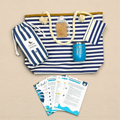 Flat lay of Navy Nautical Beach Lover Gift Set with striped beach bag, navy striped beach towel, ocean blue wine tumbler, sea turtle necklace, and bonus cards.