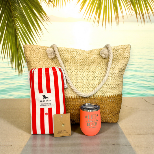 Beach Lover Gift Set in coral on a sunlit stone dock with turquoise ocean background — tropical fall getaway vibe.