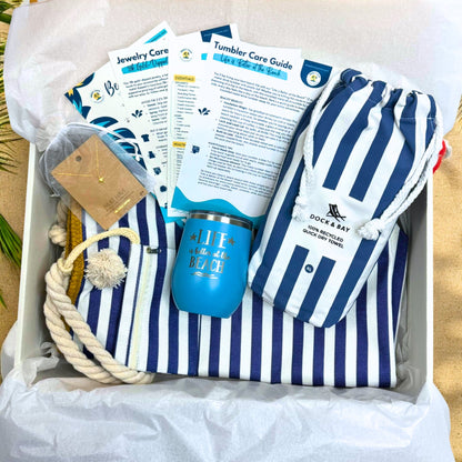 Navy Nautical Beach Lover Beach Bag Gift Set with striped towel, ocean blue tumbler, gold sea turtle necklace, and printed bonus cards in gift box.