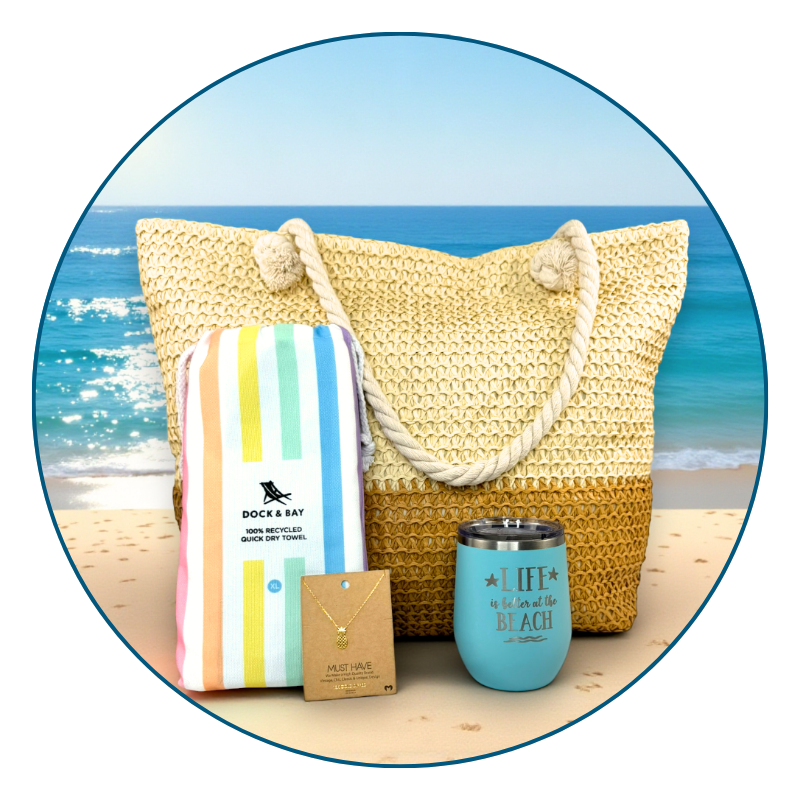 pastel beach lover gift set in a beach setting with towel, tumbler, bag, and pineapple necklace and ocean in the background