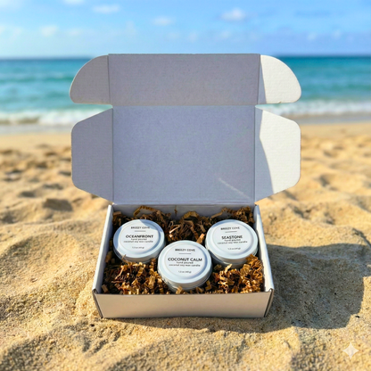 Beachside Mini Candle Trio gift box with Oceanfront, Coconut Calm, and Seastone candles displayed on sand by the ocean.