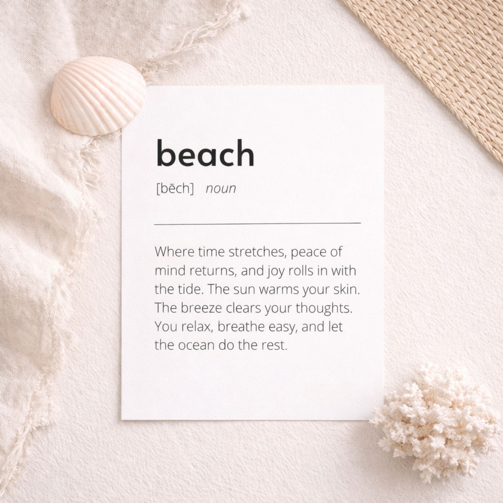 Beach definition art print flat lay on soft neutral fabric with seashell and woven mat