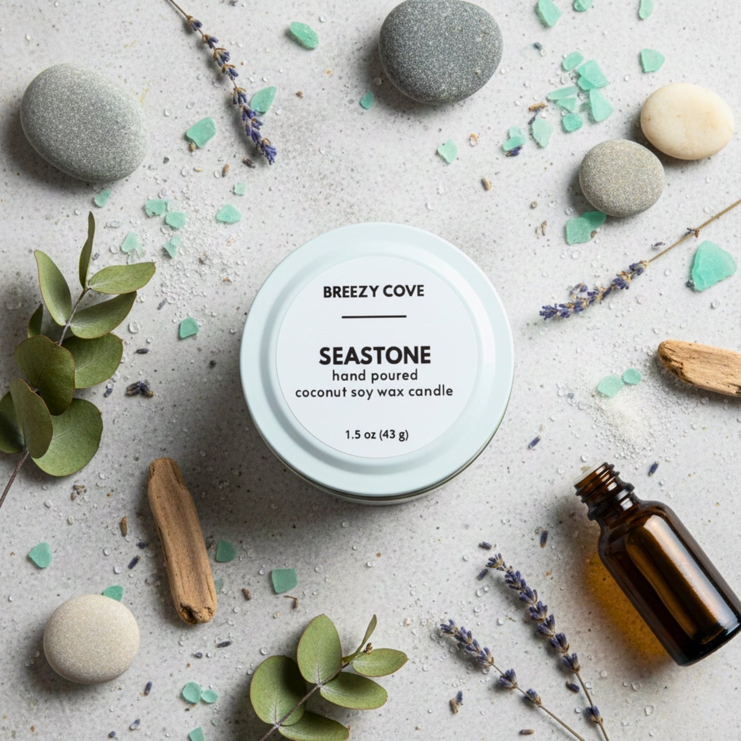 Seastone beach themed mini candle with sea glass, stones, and botanicals for a calm coastal scent.