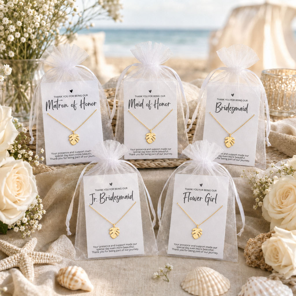 Beach wedding bridal party gifts for bridesmaids, maid of honor, matron of honor and flower girls on a gift table with the ocean in the background