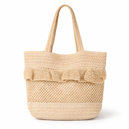 Beige straw crochet beach tote bag with ruffle detail on a white background.