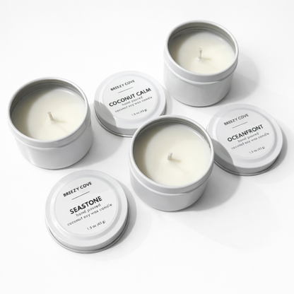 Open nontoxic long-burning beach candles in white tins shown with lids off.