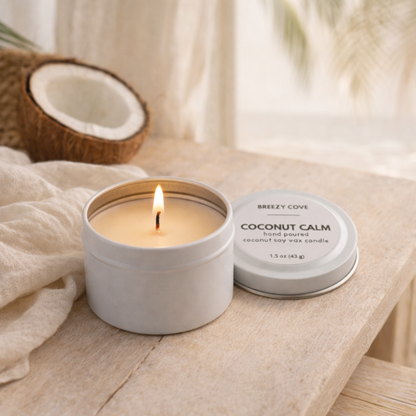 Coconut Calm coconut beach scented mini candle tin surrounded by coconut pieces and fresh greenery in a tropical setting