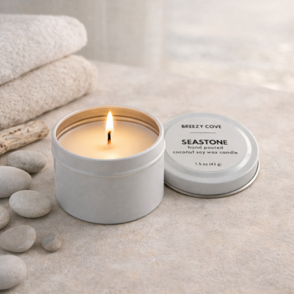 Seastone beach scented mini candle tin with in a beach spa setting for a calm coastal scent.