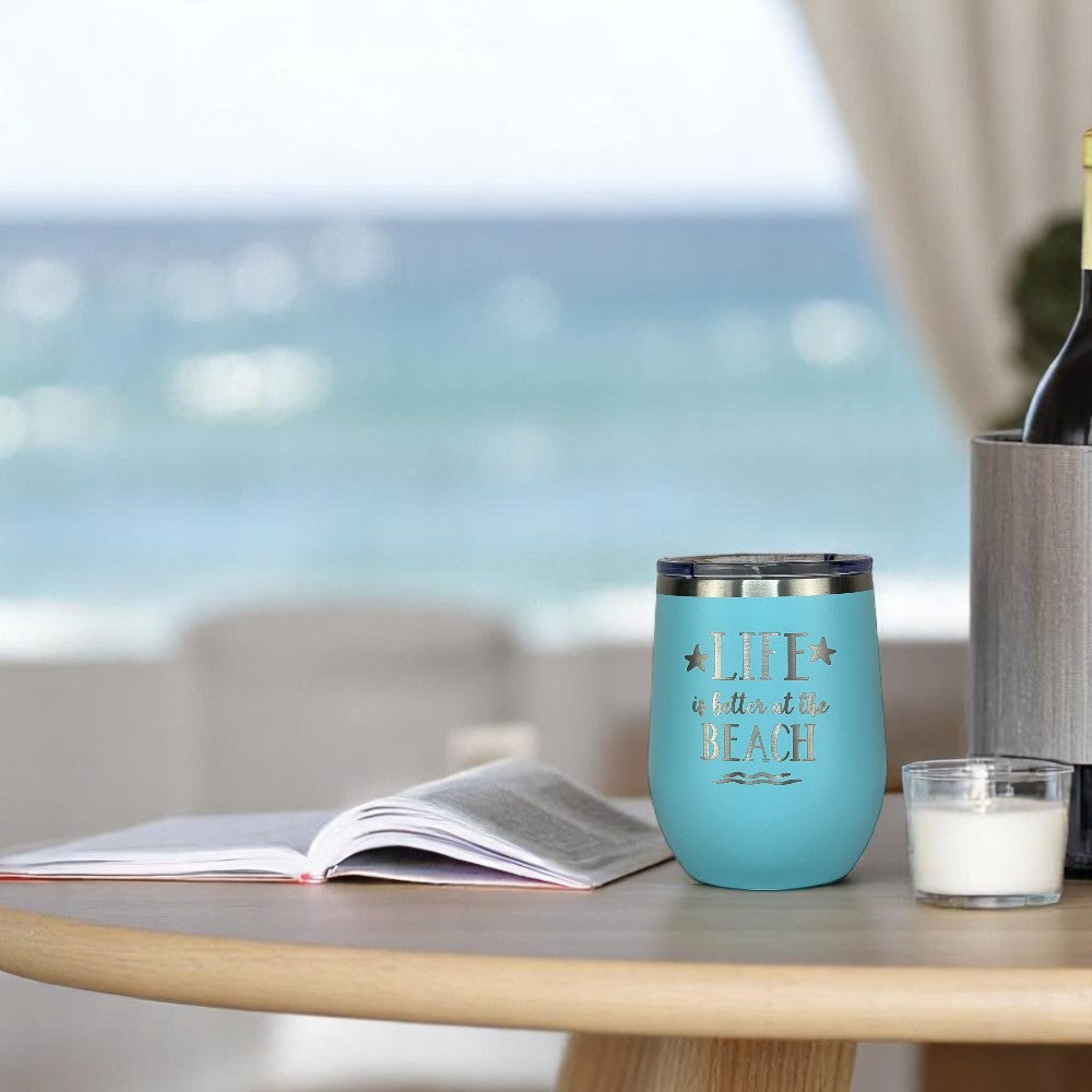 Teal 12 oz insulated tumbler on side table with candle and book