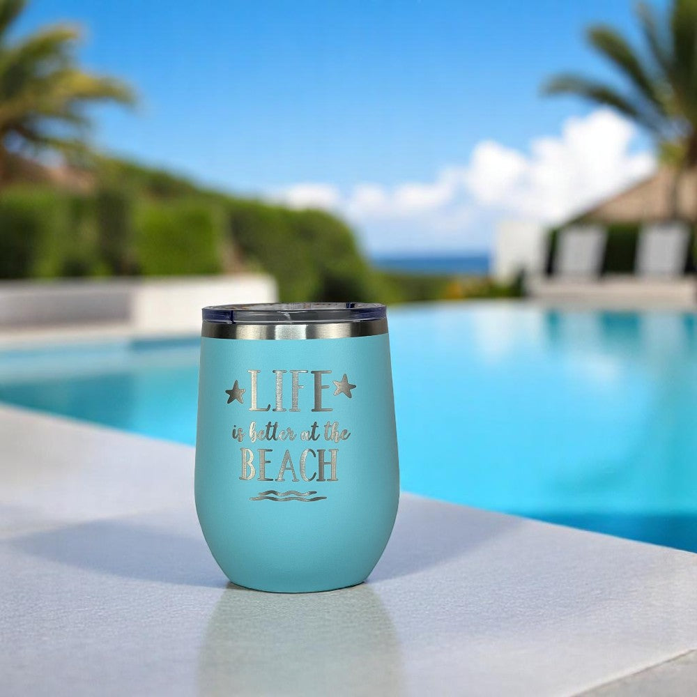 Teal 12 oz insulated beach wine tumbler by a pool, engraved with “Life is Better at the Beach.”