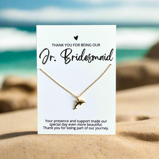 an 18k gold dipped dolphin necklace on a bridesmaid thank you card for an affordable bridal party gift for beach wedding