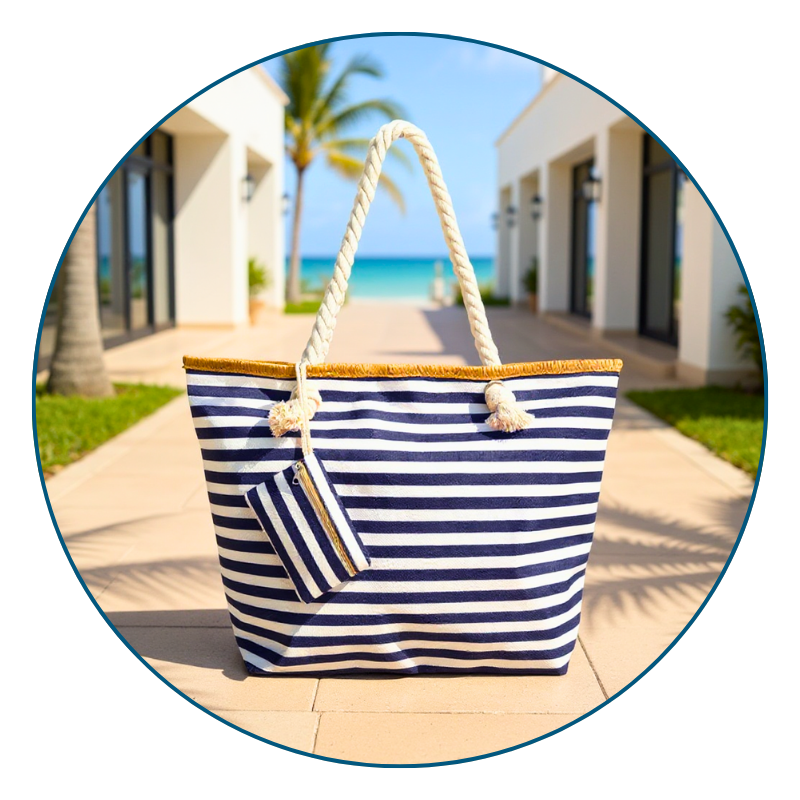 Navy striped beach bag on a sunlit resort patio with ocean backdrop — classic coastal style for beach days, travel, or everyday use.
