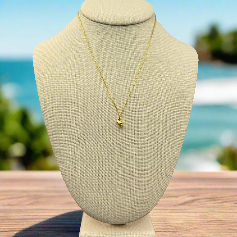 dainty, conch pendant necklace 18k gold dipped necklace is perfect jewelry accessory for beach lovers on linen jewelry display with ocean backdrop