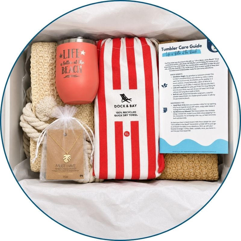 Coral beach lover gift set in a gift box with straw beach bag, coral striped towel, peach tumbler, gold-dipped monstera necklace and bonus cards.