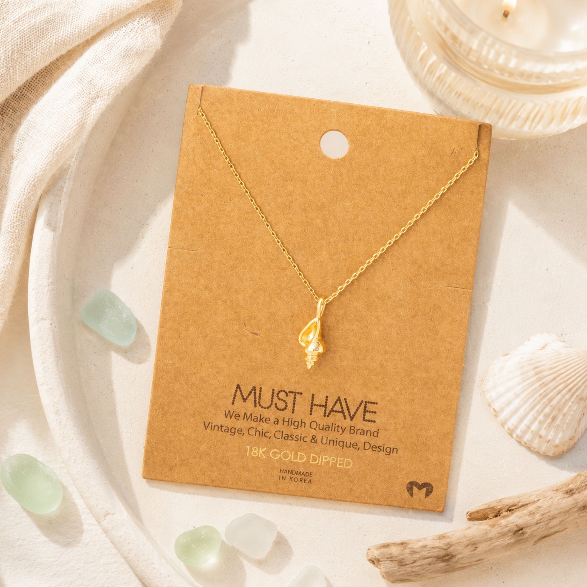 Dainty gold conch shell necklace on jewelry card styled with coastal beach accents — 18k gold dipped beach necklace for women