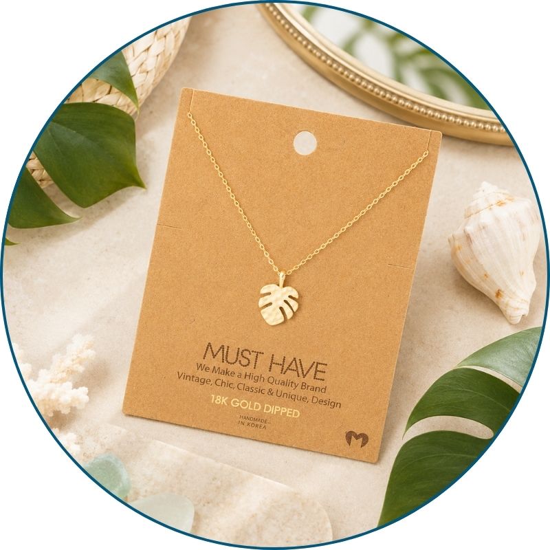 Gold monstera leaf necklace on jewelry card with white organza gift bag — 18k gold dipped tropical beach necklace ready to gift