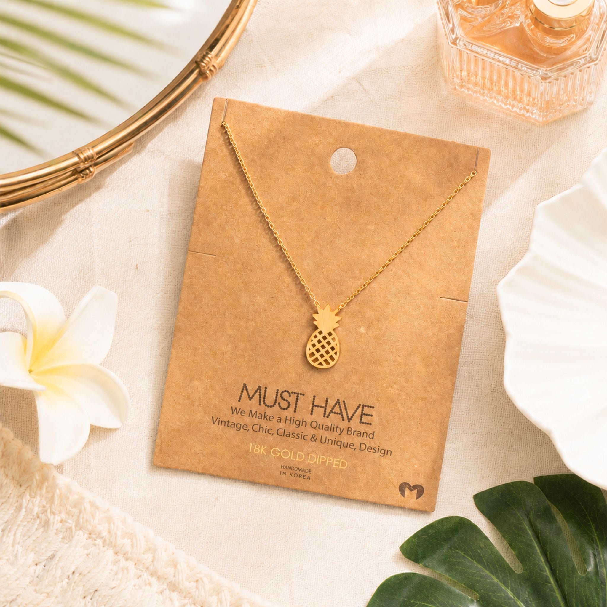 Dainty gold pineapple necklace on jewelry card styled with tropical beach accents — 18k gold dipped beach necklace for women