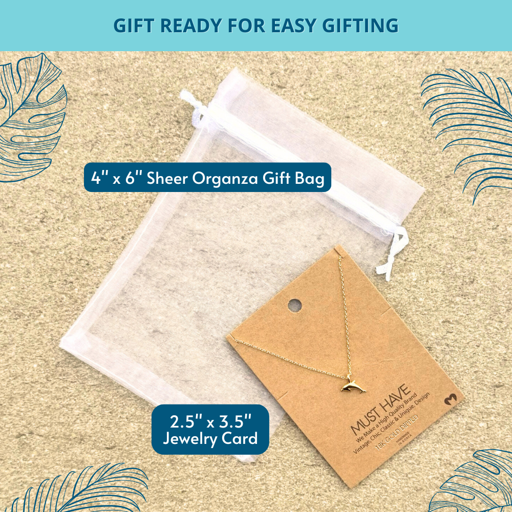 Graceful 18k gold-dipped dolphin pendant necklace nestled inside a white organza gift bag, a perfect coastal accessory