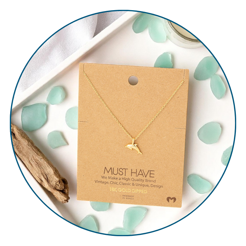 Dainty gold dolphin necklace styled for everyday wear with ocean-inspired accents.