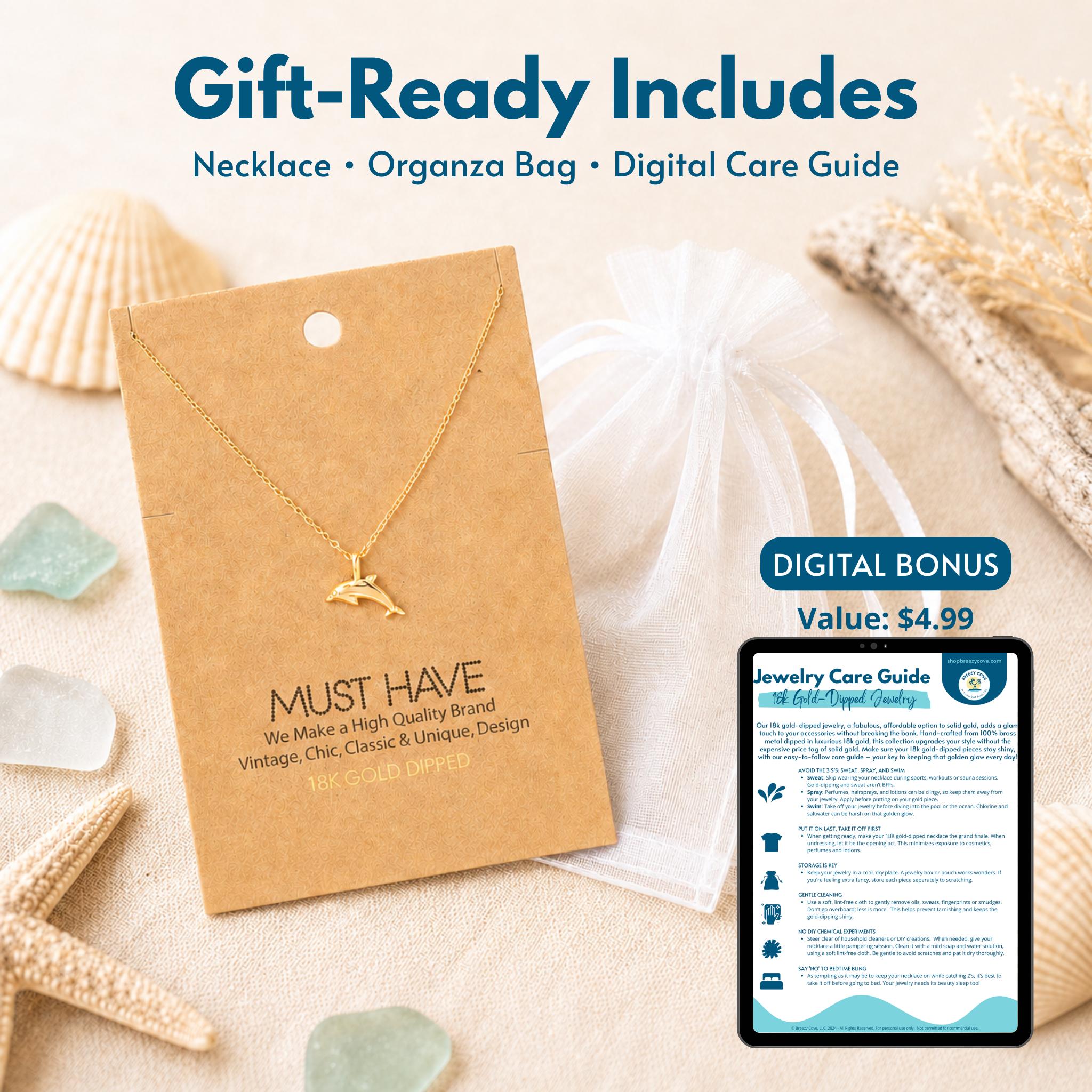 Gold dolphin necklace gift set — includes 18k gold dipped dolphin necklace on jewelry card, white organza bag, and digital jewelry care guide