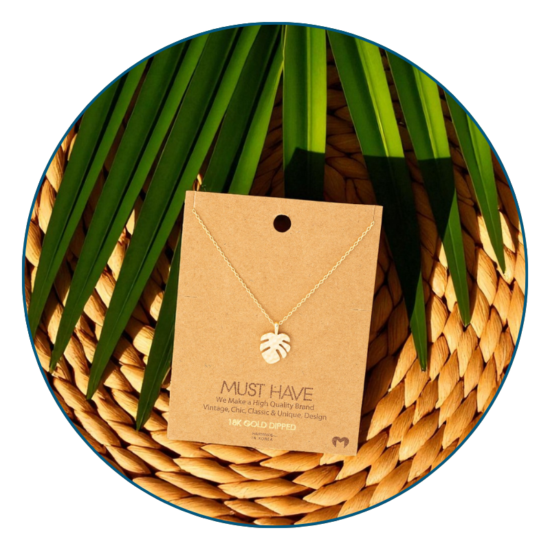 Dainty gold monstera necklace styled for everyday wear with tropical-inspired accents.