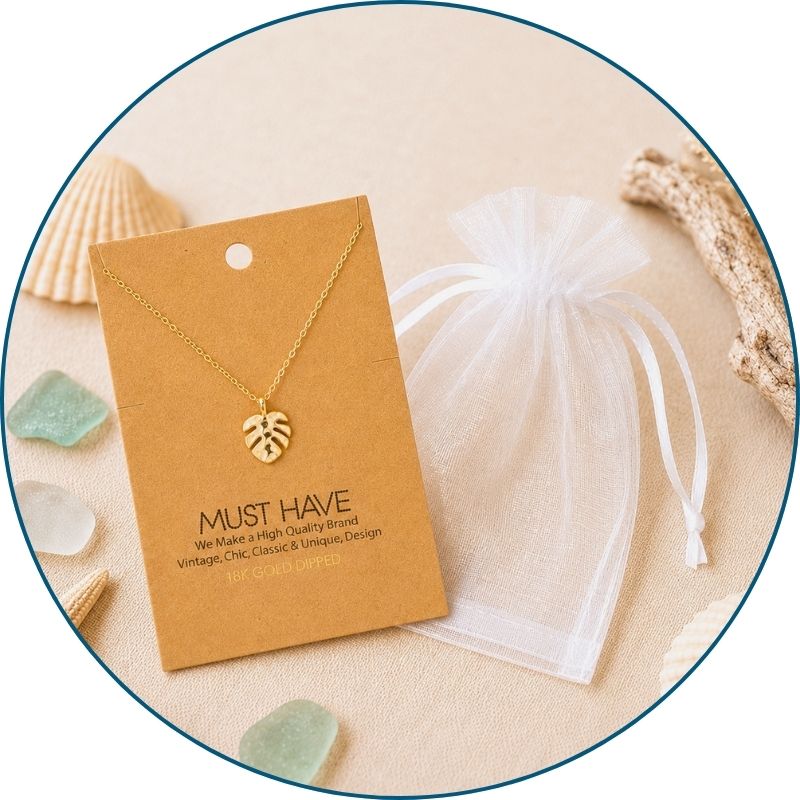 Gold monstera necklace with a white organza gift bag — 18k gold dipped monstera pendant necklace ready to gift