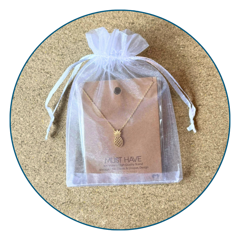 Gold pineapple necklace in organza gift bag with ribbon, perfect for gifting or jewelry storage.