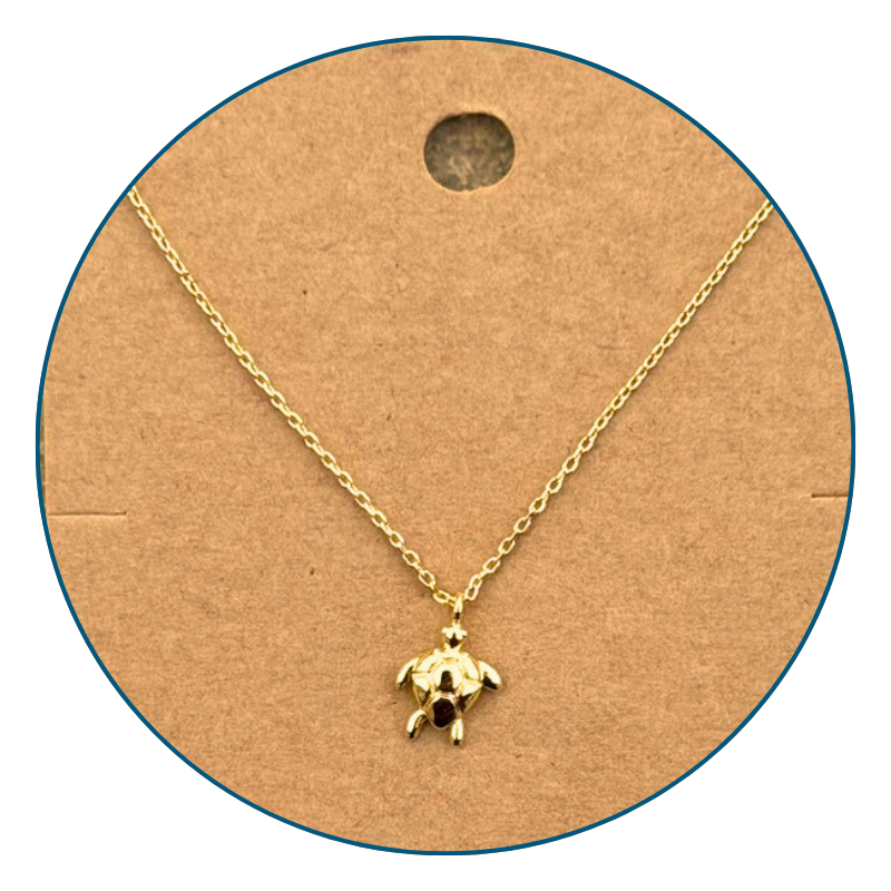 Close-up of 18k gold dipped sea turtle necklace pendant with polished golden shine and detailed turtle design.