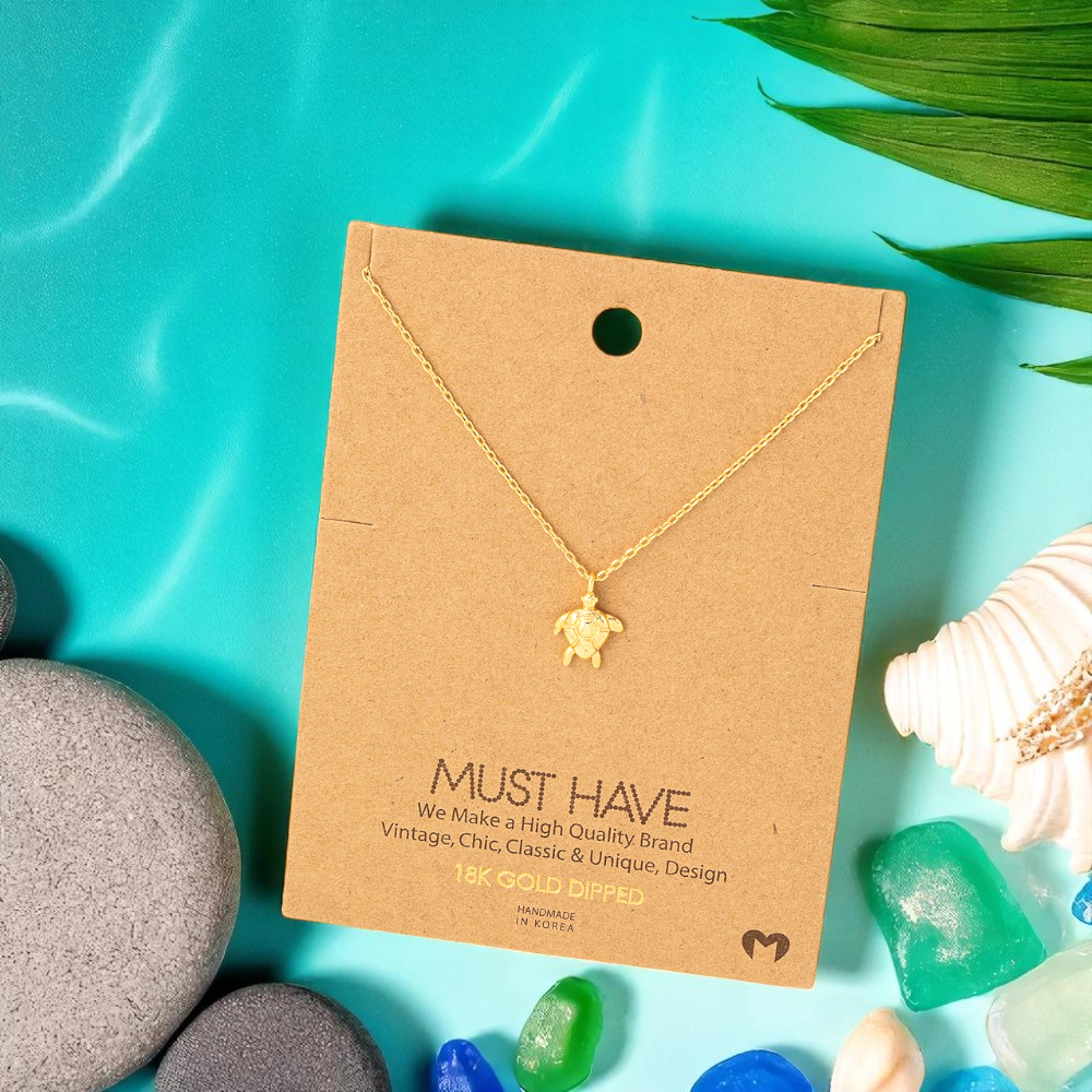 18k gold dipped sea turtle necklace styled with beach-inspired accents for women who love the ocean.