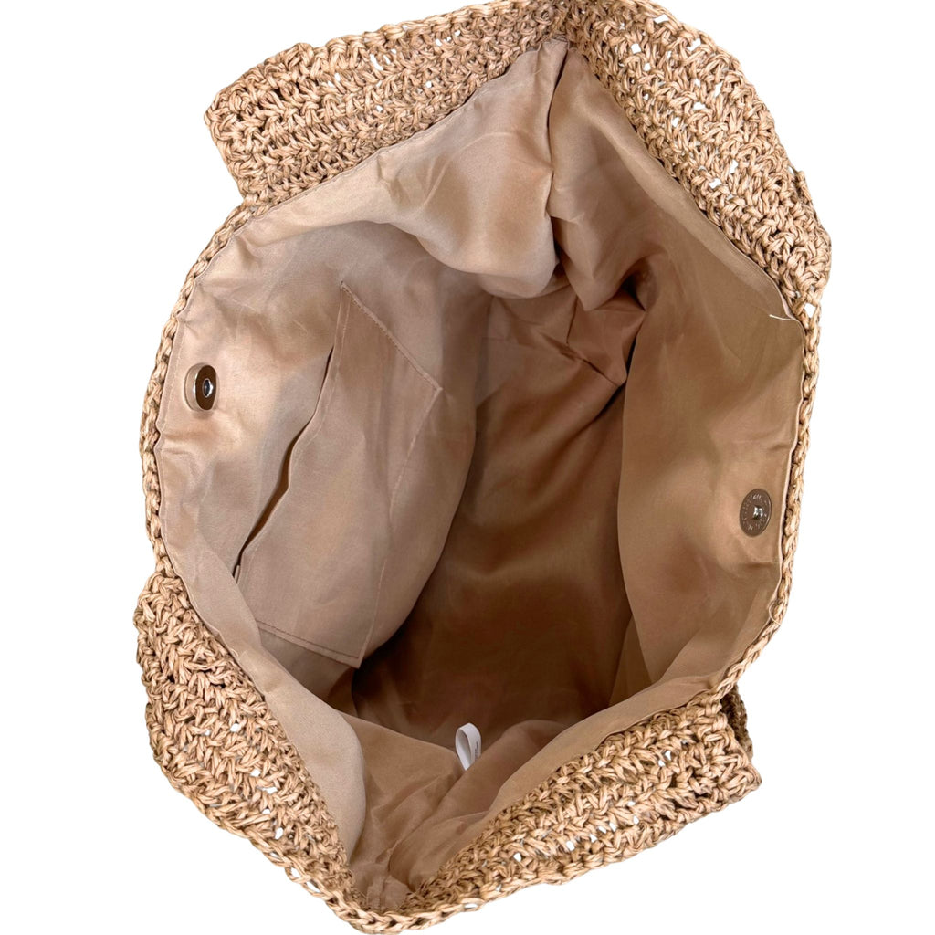 Woven straw bag with a beige interior on a white background