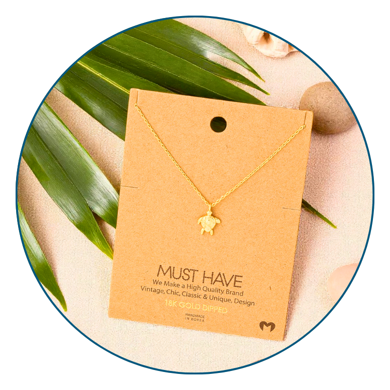 18k Gold dipped sea turtle necklace with dainty chain displayed on beach-inspired background — meaningful coastal jewelry for women.