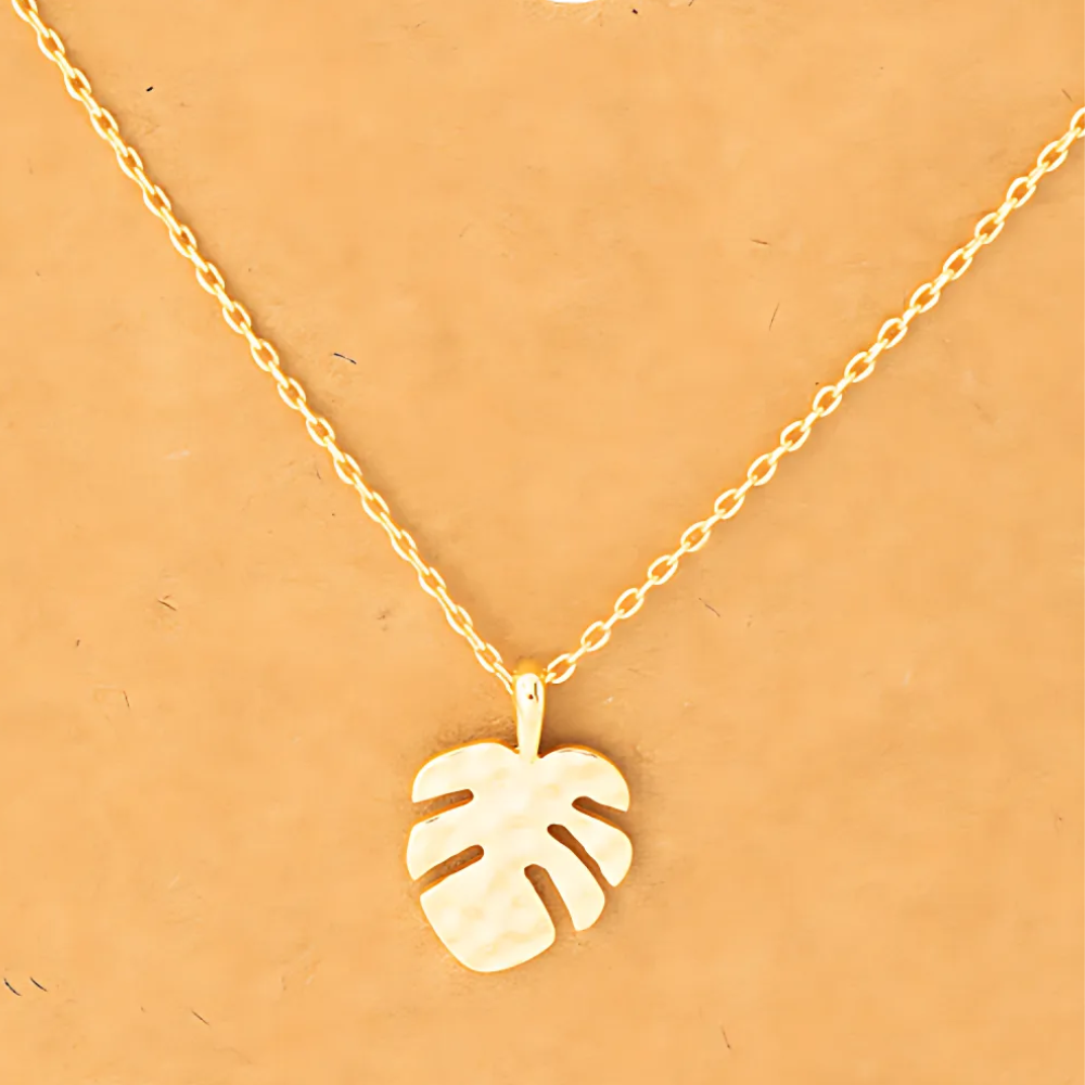 Detailed close-up of the 18k gold-dipped hammered monstera leaf pendant necklace, emphasizing its textured surface and tropical-inspired design