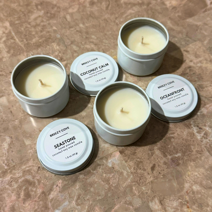 Open nontoxic long-burning beach candles in white tins shown with lids off.