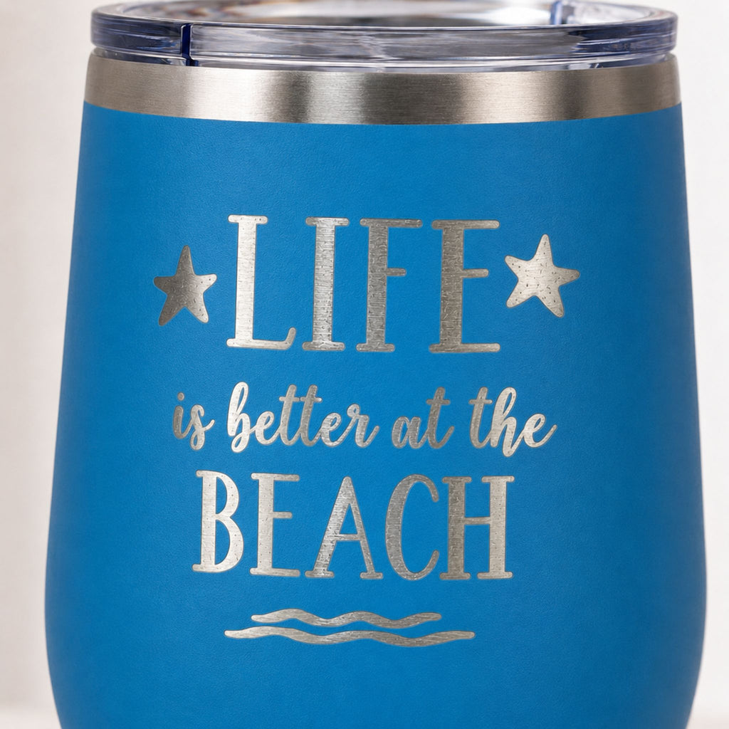 Close-up of ocean blue beach tumbler with Life is Better at the Beach design