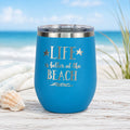Ocean blue wine tumbler with lid styled for beach days and coastal sipping