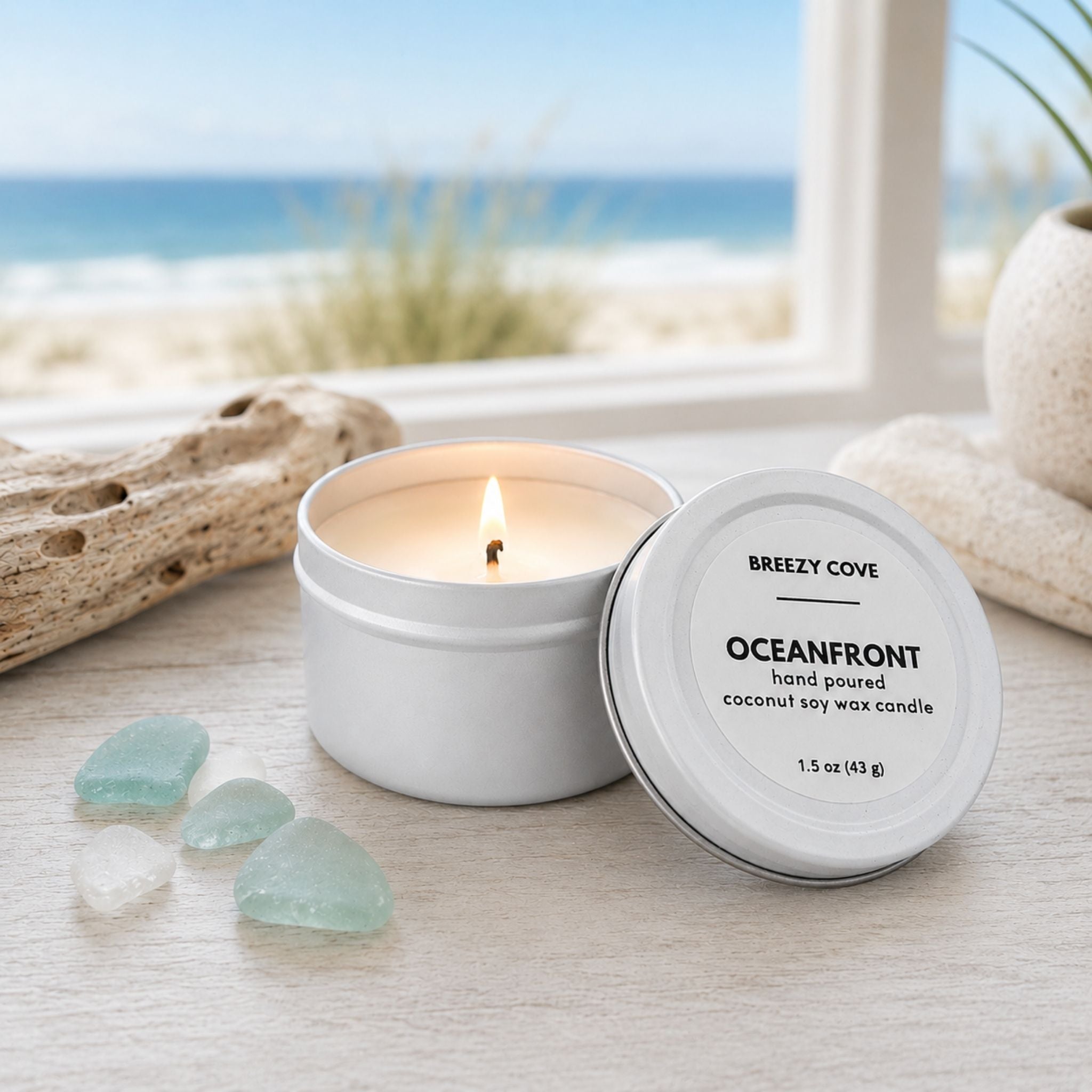 Lit Oceanfront beach candle from the Beachside Mini Candle Trio in a coastal setting with sea glass and an ocean view.