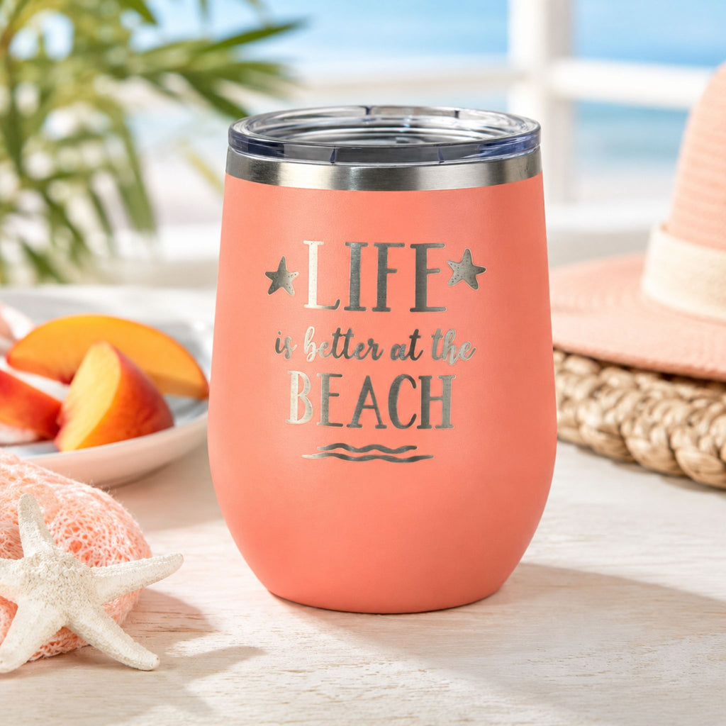 Peach beach tumbler cup with lid for cold drinks in a bright coastal setting